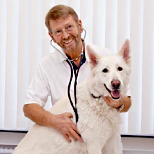 Tierarzt Klaus Sperling mit einem weißen Hund